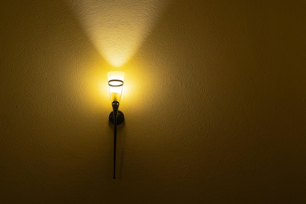 写真 レトロなシェードが付いたヴィンテージの電灯が古いレンガの壁のロフトを照らします