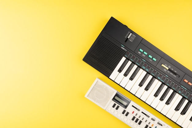 Photo vintage electronic keyboard synth piano on yellow background