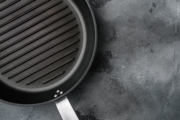 Vintage empty grill pan set with copy space for text or food with copy space for text or food, top view flat lay, on gray stone table background