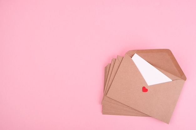 ピンクの背景にヴィンテージの封筒。ロマンチックな手紙。上面図。スペースをコピーします。バレンタインデーと愛のコンセプト。