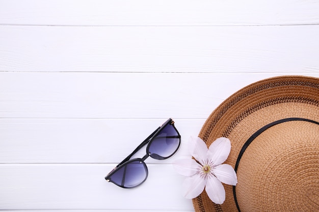 Vintage fabricate straw hat and sunglasses on white.