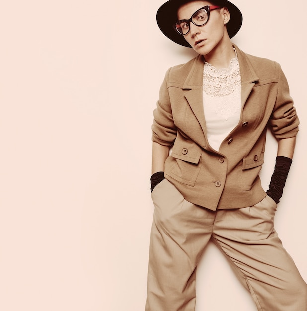 Vintage Fashion Woman Beige classic suit and stylish eyewear. Black hat. Black gloves. Glam retro style trend Autumn Winter