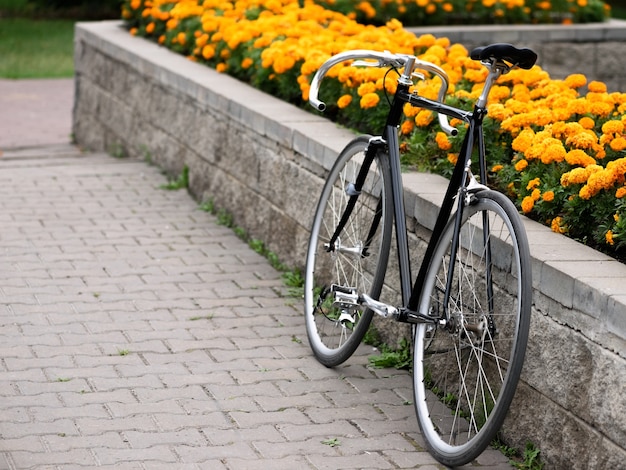 Vintage fiets over bloembed met gele bloemen