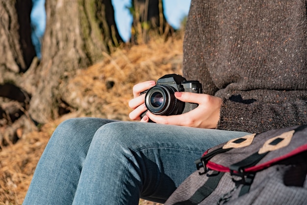 Foto fotocamera a pellicola vintage in mani femminili. immagine ravvicinata di una donna che tiene la fotocamera a pellicola all'aperto