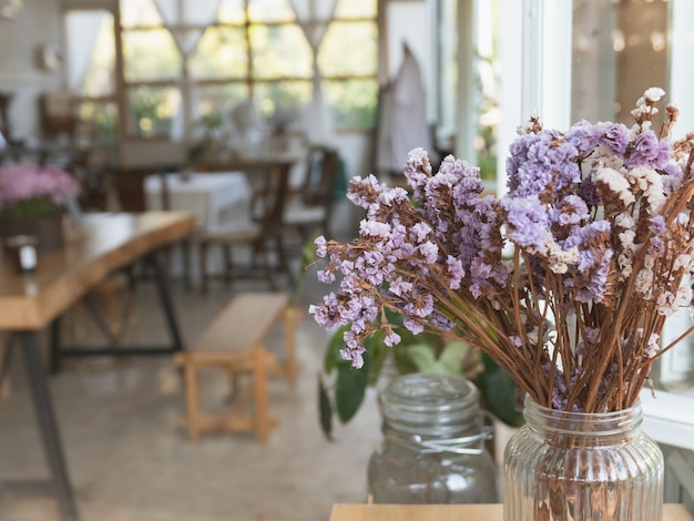 カフェの木製テーブルの上のヴィンテージの花