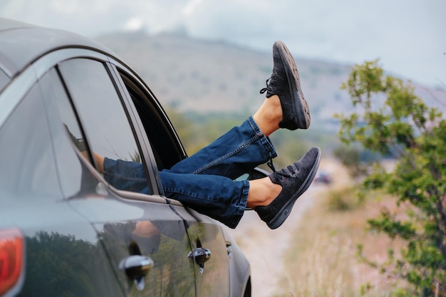 Vintage foto van een beenvrouw in de auto tijdens de ochtendvakantie Het idee en concept van vrijheid, rust en ontspanning