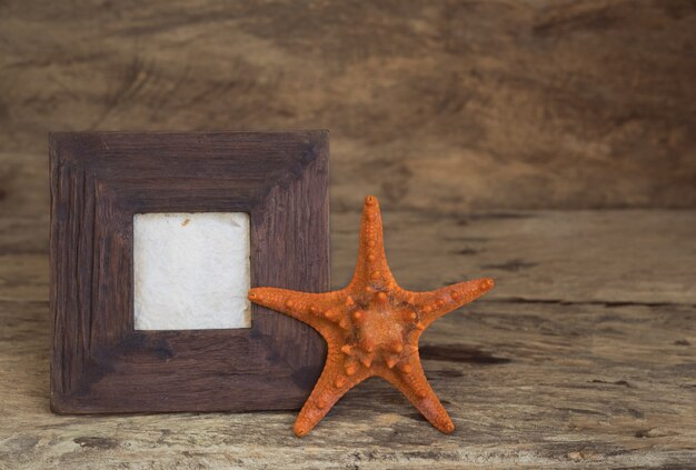 Vintage fotolijst met zeesterren op houten tafelblad achtergrond