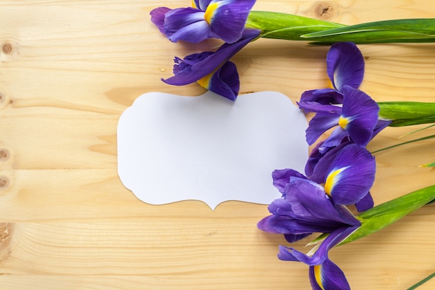 Vintage frame and irises on wooden background