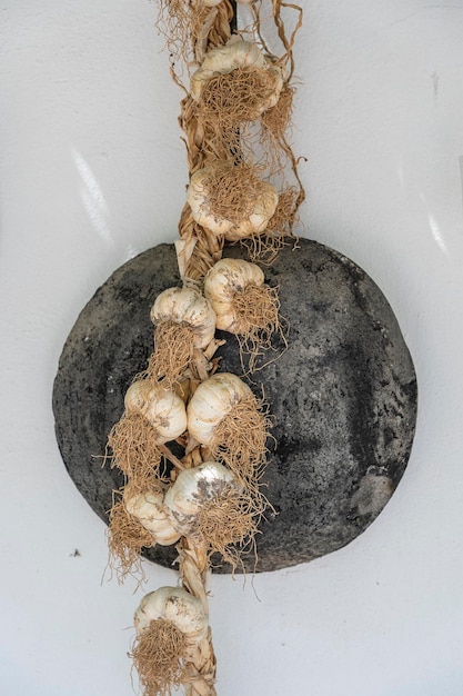 Vintage frying pan and bunch of garlic on a white wall close up Kos island Greece