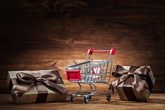 Vintage giftboxes and shopping cart on wood