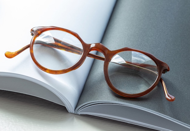 Винтажные очки, лежащие на открытой книге с пустыми страницами