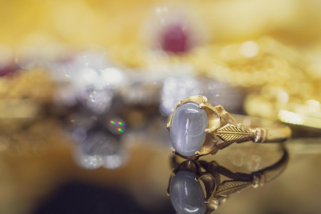 Photo vintage gold jewelry blue sapphire rings with reflection on black background