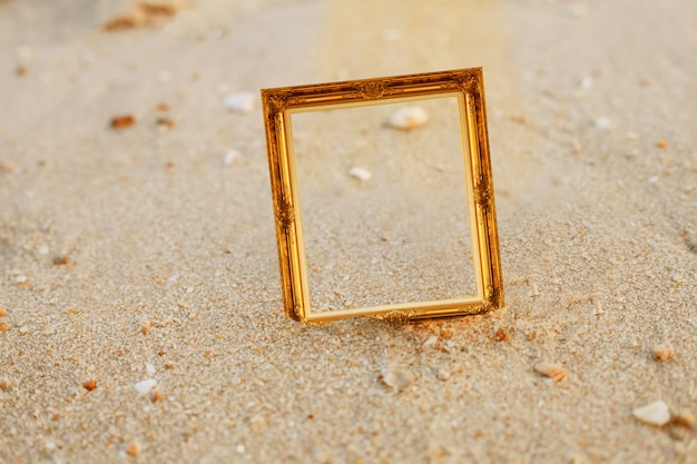 Vintage gold picture frame on sand beach.