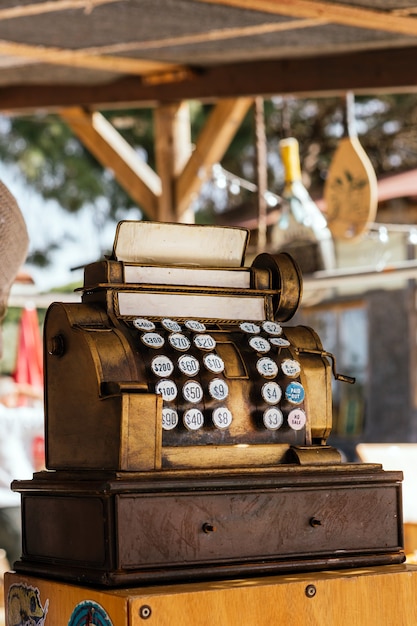 Vintage golden cash register machine at sale in an antiques market