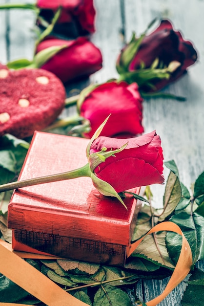 Vintage graan rozen op doos en feestelijke koekjes met harten Valentijnsdag