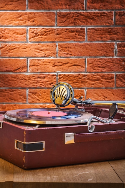 Grammofono vintage sul tavolo e sullo sfondo del muro di mattoni