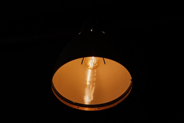 검정색 배경이 있는 빈티지 매달려 있는 실내 램프, 백열 램프.