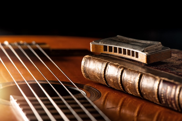 Vintage harmonica on acoustic guitar