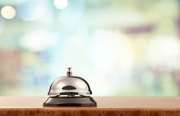 Vintage hotel reception service desk bell on blurred background, bokeh
