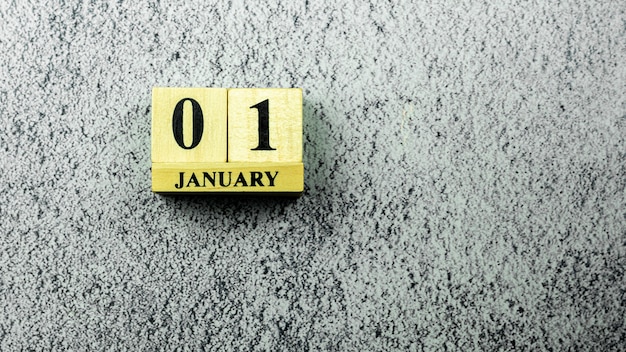 Vintage houten kalender ingesteld op "01 januari" op betonnen vloer.