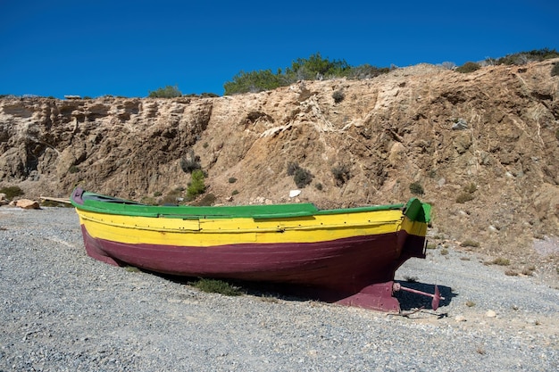 Vintage houten vissersboot afgemeerd op lege kiezelkust achtergrond Gavdos eiland Kreta Griekenland