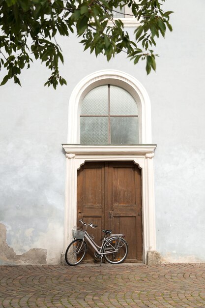 写真 イタリアの壁に自転車が付いている古いドアのビンテージ イメージの背景