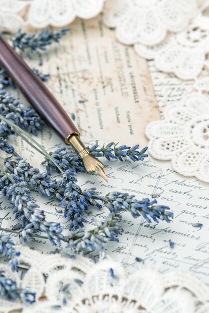 ヴィンテージのインクペン、乾燥したラベンダーの花、古いラブレター。レトロなスタイルのトーンの写真