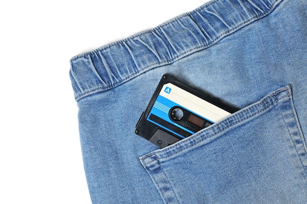 Vintage jeans with audio cassette in pocket close up on isolated white backgroundxDxA