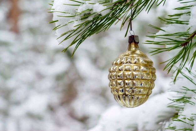 Vintage kerstversiering op een levendige spar in besneeuwd winterbos buiten