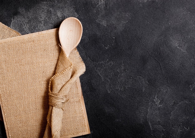 Vintage keuken houten keukengerei met linnen bord op stenen tafel. Bovenaanzicht.