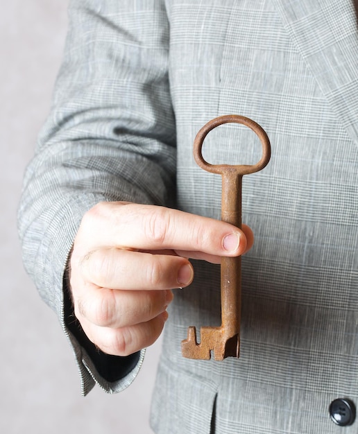 A vintage key in the hand of a man in a classical costume.Closeup