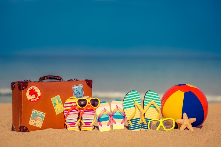 Foto vintage koffer en slippers op zandstrand tegen blauwe zee en lucht