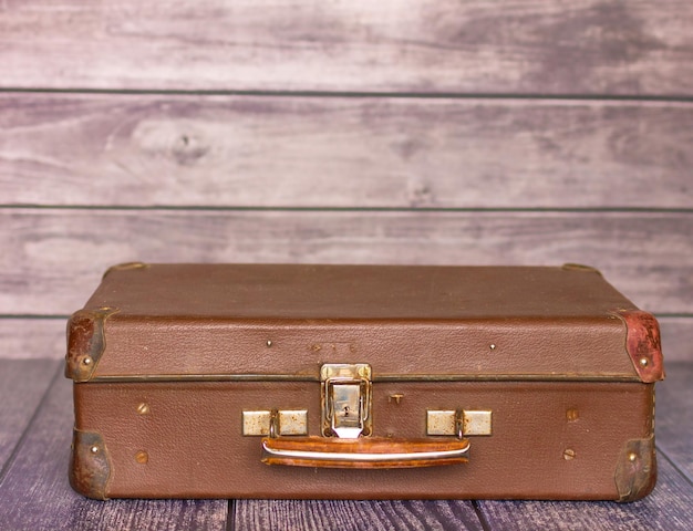 vintage koffer in de stijl van de jaren 50 op de achtergrond van een houten muur of textuur, close-up foto. reisconcept. kopieer ruimte