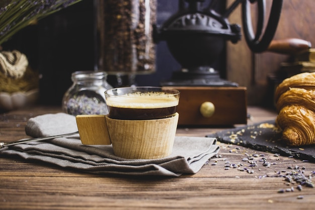 vintage koffiemolen koffie en croissant op een donkere achtergrond