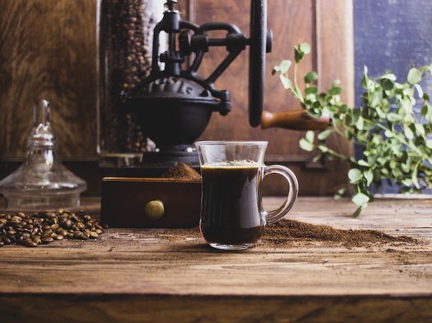vintage koffiemolen koffie en croissant op een donkere achtergrond