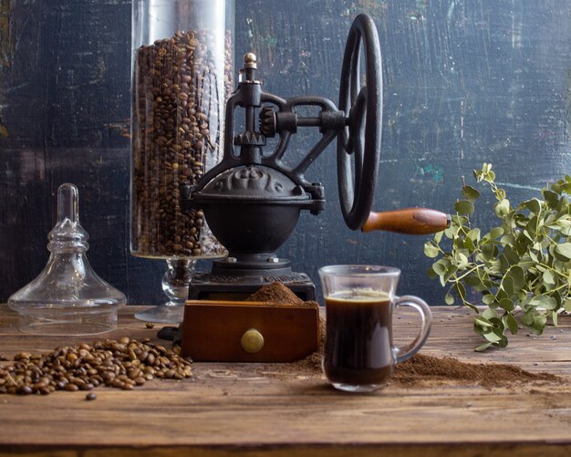 vintage koffiemolen koffie en croissant op een donkere achtergrond