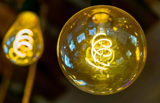 Vintage lampen in een glazen kolf met een wolfraamdraad erin op een donkere achtergrond in bar pub