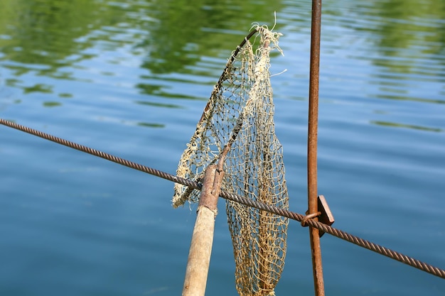 川の選択的な焦点で魚を捕まえるためのビンテージランディングネット