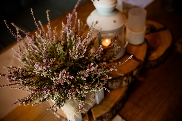 Vintage lantaarn met kaars en bos decor. herfststijl, café, restaurant romantische decoratie. herfst witte lantaarn versierd met kleurrijke bladeren en heidekrans.