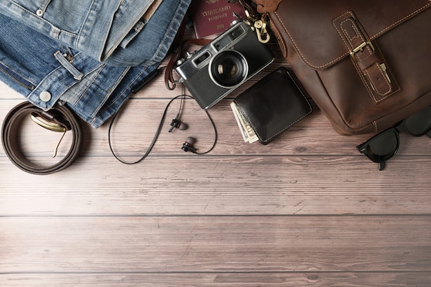 Vintage leather bag and old jeans on wood 