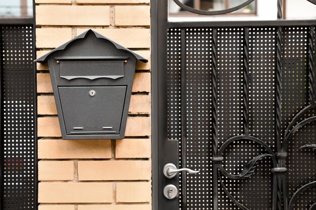 Vintage letter box on beige brick wall near door outdoors