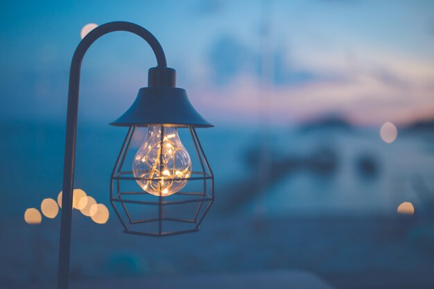 Lampadine vintage decorate nel soggiorno, vista mare al tramonto.