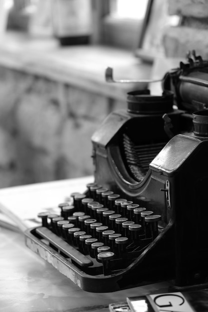 Photo vintage manual typewriter atop a wooden desk with two hardcover books placed beside it