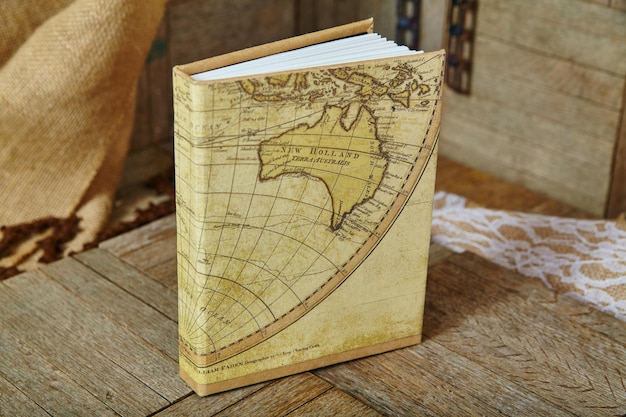 vintage map book cover on rustic wooden surface with lace background