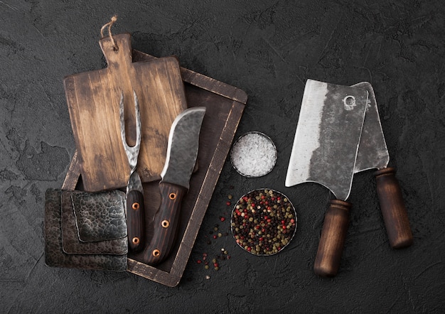 Vintage meat knife and fork and hatchets with vintage chopping board