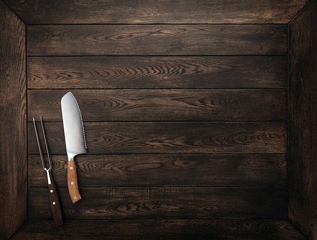 Vintage meat knife and fork over wood table