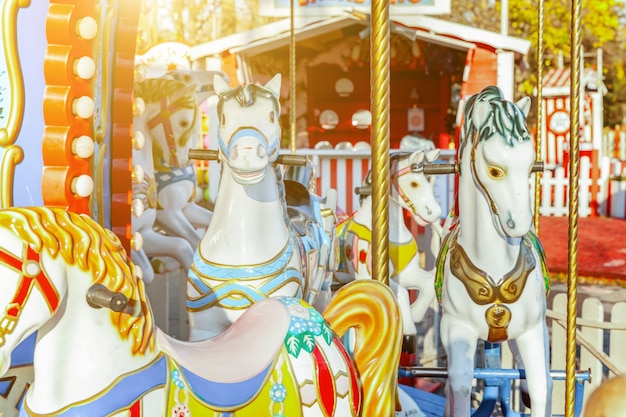 Vintage merry-go-round flying horse carousel in amusement\
holiday park