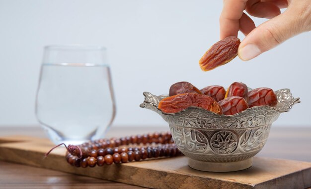 Vintage metalen schaal vol ontpitte dadelvruchten op houten tafel. Traditioneel iftar-eten. symboliserend