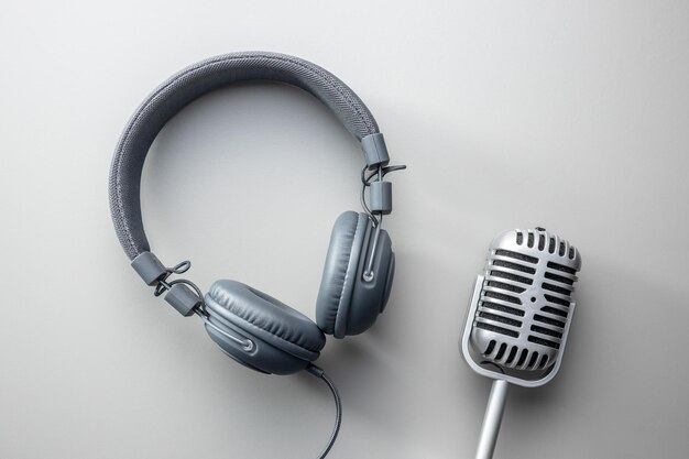 Vintage microphone and headphones on gray background Top view