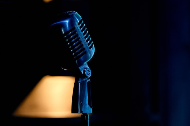 Vintage microphone on the rack in a blue backlit assurance.\
high quality photo